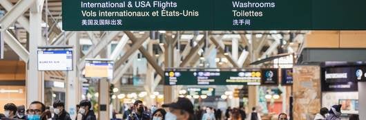 Airport terminal at the Vancouver International Airport with passengers wearing face mask